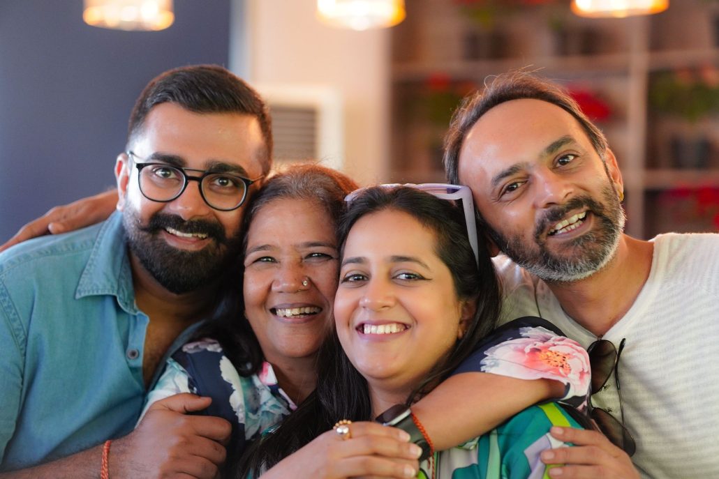Smiling parents embracing their two adult children, representing family trust and estate planning decisions.